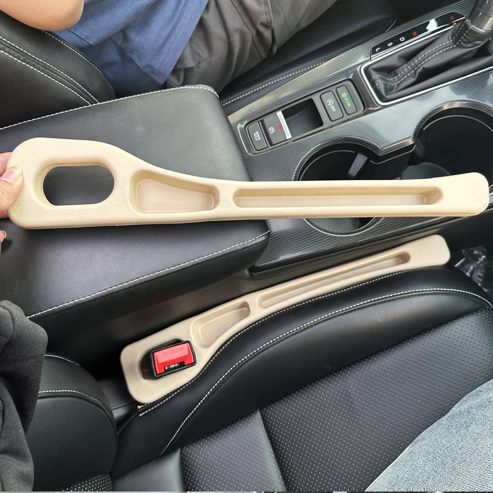 A beige car seat gap filler and storage organizer is shown in the interior of a vehicle.