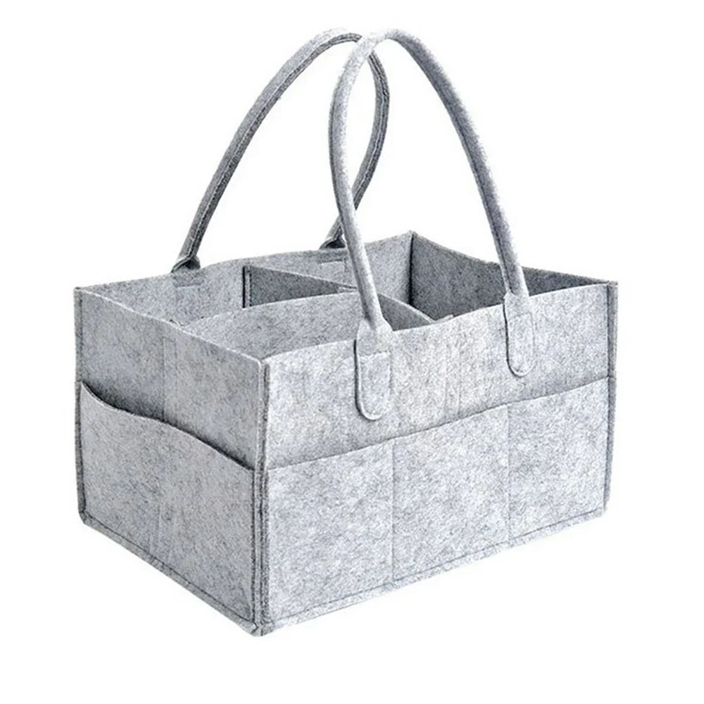 A gray portable canvas diaper storage organizer with handles is shown from above.