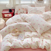 A set of white bedding featuring a pink bow print on a duvet cover and pillows.