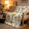 A cozy high-density short plush throw blanket with a repeating pattern of yellow cartoon animals draped over a wooden chair.