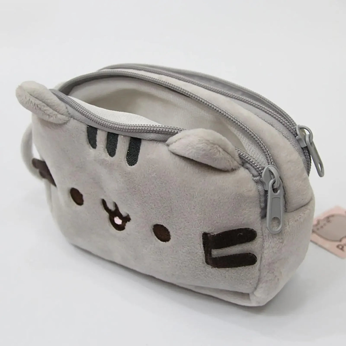 A soft gray cat plush pencil case with a zipper closure is shown from the front.