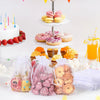 White organza drawstring bags filled with pink and yellow treats for gifts and party favors