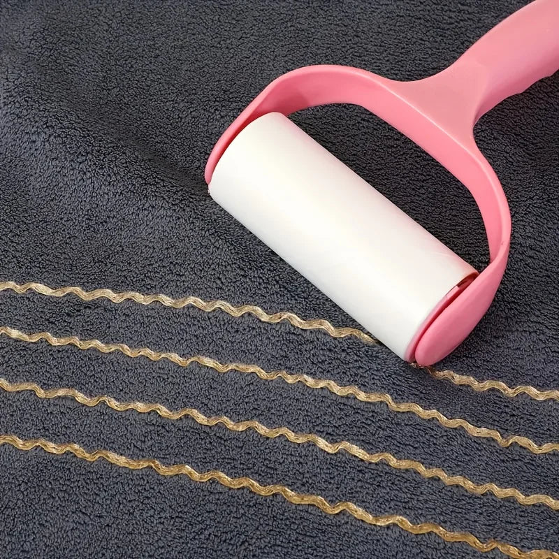 A pink plastic towel ring holds a roll of gold-striped towel fabric on a dark gray towel.