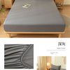 A gray soft brushed fitted sheet is displayed on a bed, showing its texture and elastic edge.