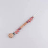 A beaded silicone pacifier clip with a wooden baby teething lanyard and pink floral accents.