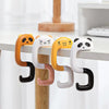 A set of four cute panda-themed silicone hooks in orange, white, yellow, and black hanging from a wooden surface.