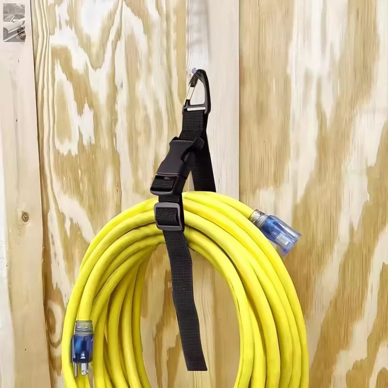 A yellow heavy duty extension cord organizer with black straps and a buckle lock is shown against a wooden background.
