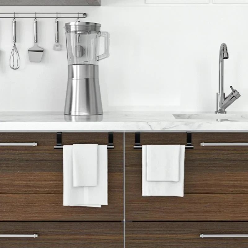 A stainless steel blender and a white towel rack are displayed above a dark wood kitchen cabinet.