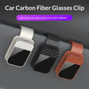 Three car carbon fiber glasses clips in white, black, and orange colors shown on a gray surface.