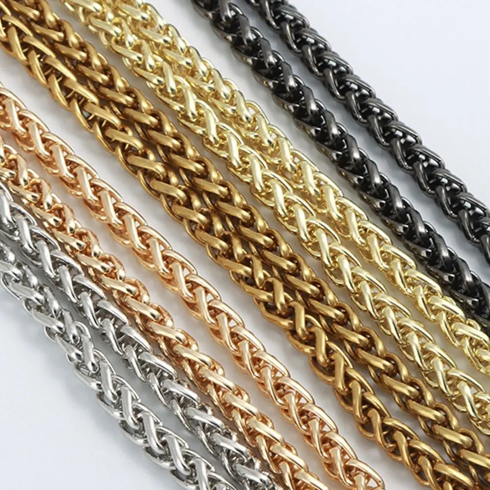 A close-up of multiple strands of elegant metal chain straps in gold, silver, and black.