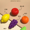A collection of colorful fruit shapes, including a red tomato, yellow lemon, purple grapes, and green lime, arranged for sort