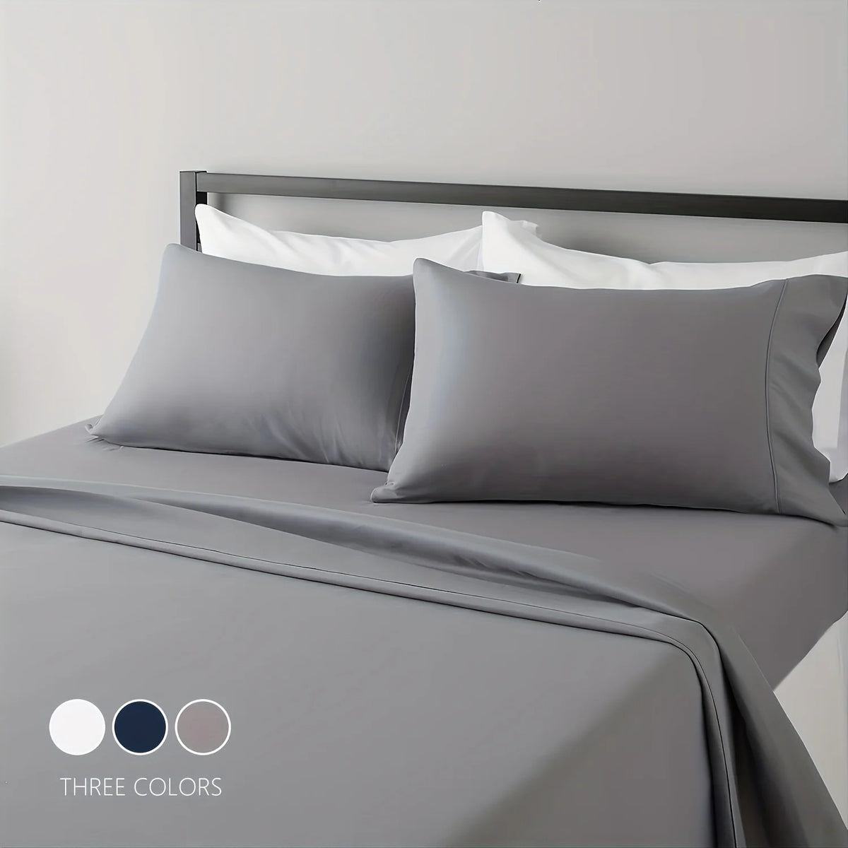 A gray microfiber bed sheet set with white pillows and a matching gray duvet on a bed.