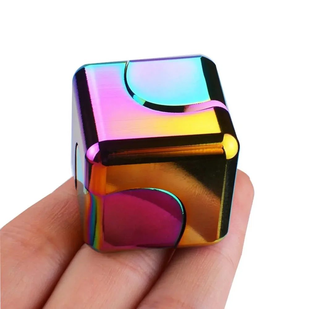 A vibrant, iridescent alloy metal fidget cube spinner held in a hand.
