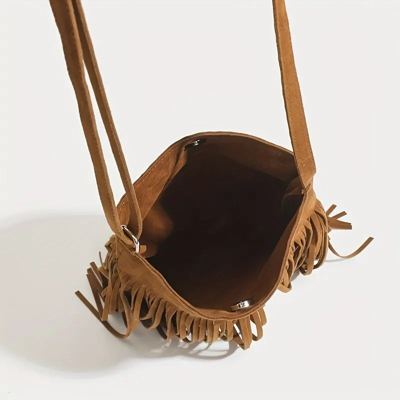 A brown bohemian fringe shoulder bag with leather straps and tassels shown from the opening.