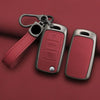 A red leather key case cover with a metal clip and a rectangular key fob attached, resting on a maroon surface.