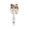 A cute hamster character with brown fur and pink bow is attached to a silver badge reel.