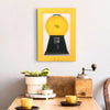 A yellow vintage rotating candy display frame with a dust cover is mounted on a white wall.