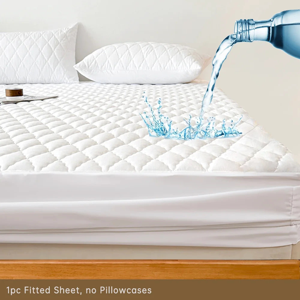 A white fitted sheet mattress protector is shown with water splashing onto the surface.