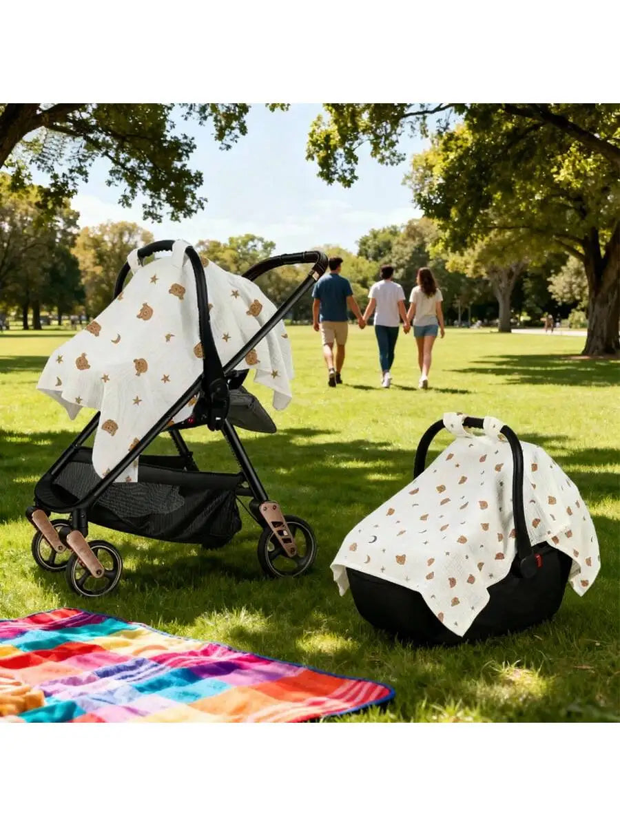 A white breathable stroller cover with sun and dust protection is shown on a stroller in a grassy park setting.