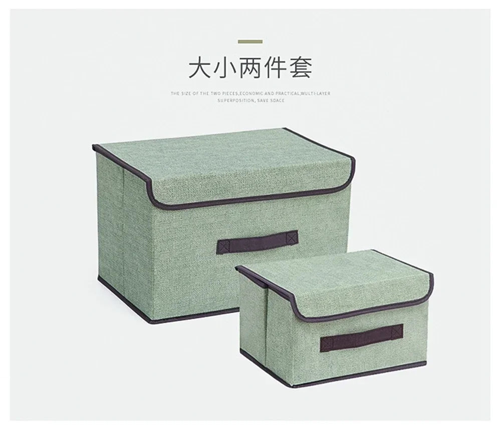A set of two rectangular fabric storage boxes in a muted green color with dark trim.