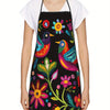 A woman wearing a black apron with a colorful floral print over a white shirt.
