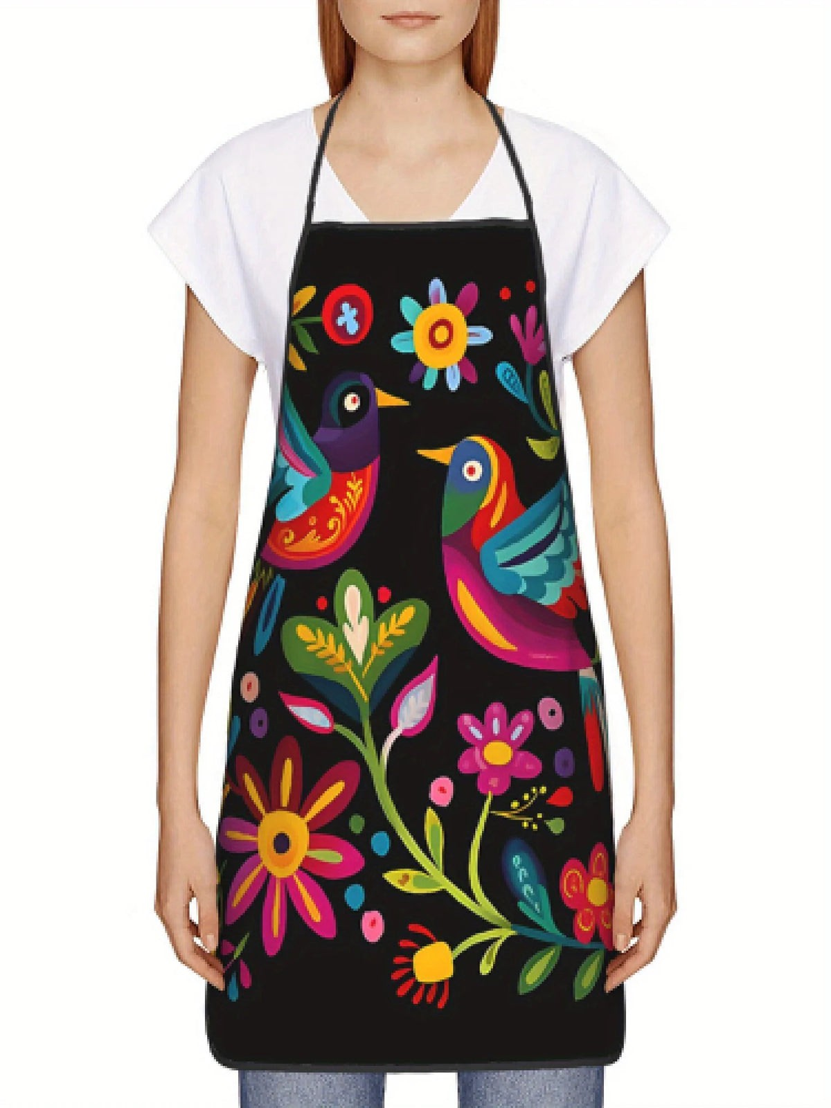 A woman wearing a black apron with a colorful floral print over a white shirt.