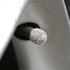 A close-up of a round, brilliant crystal-cut tire valve cap resting on a dark surface.