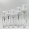 A row of clear plastic bottles containing white foaming soap dispensed into various volumes including 50ml, 60ml, 100ml, 150m