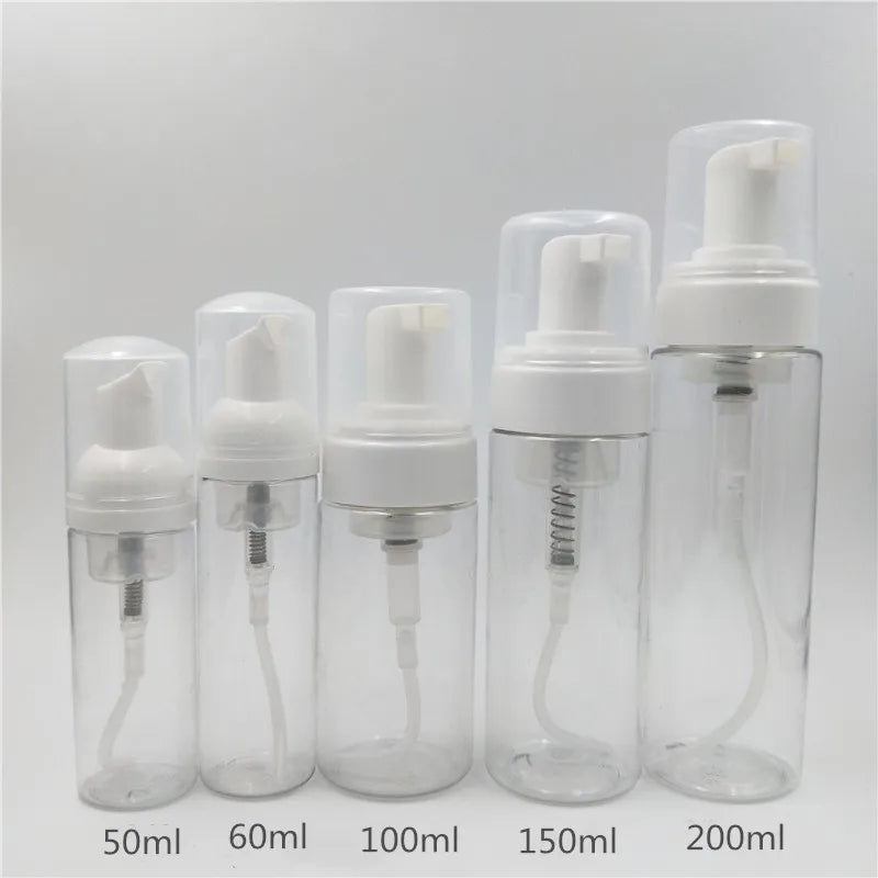 A row of clear plastic bottles containing white foaming soap dispensed into various volumes including 50ml, 60ml, 100ml, 150m