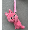 A pink, fluffy plush doll shaped like an animal with large ears and a stitched face, hanging from a pink strap.