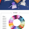 A set of drawstring organza gift bags in various colors and shades arranged on a wooden tray.