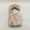 A wooden baby closet divider set with the numbers 6-9 months carved into it, packaged in clear plastic.