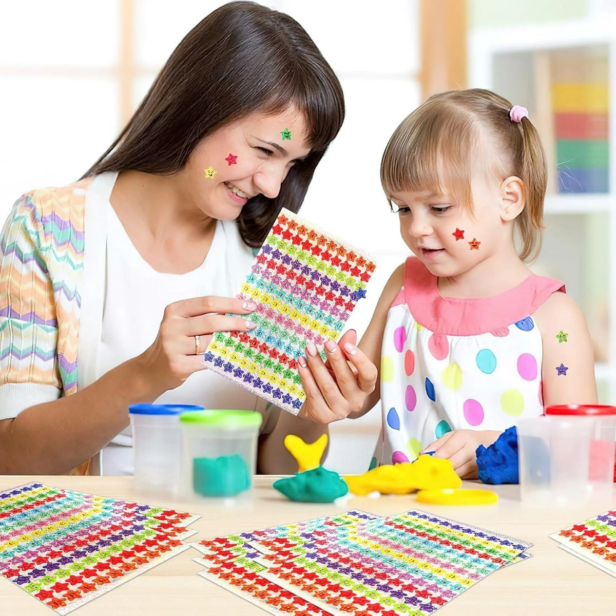 A woman and a child are using a glitter star sticker set to create colorful patterns on a table.