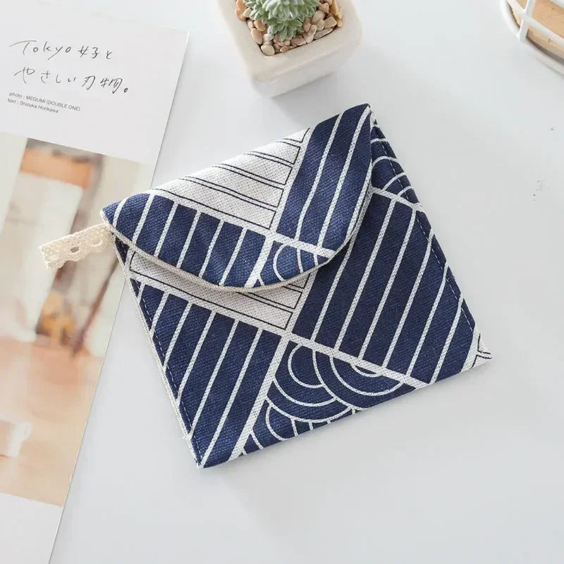 A navy blue and white striped cosmetic storage pouch with a patterned fabric is shown on a white surface.