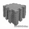 A stack of interlocking foam play mats with a hexagonal pattern, gray in color.