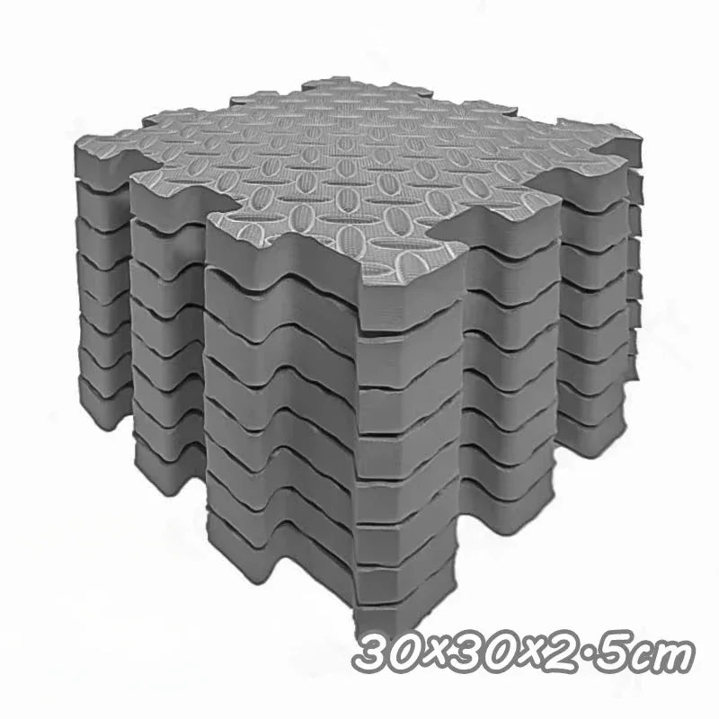 A stack of interlocking foam play mats with a hexagonal pattern, gray in color.