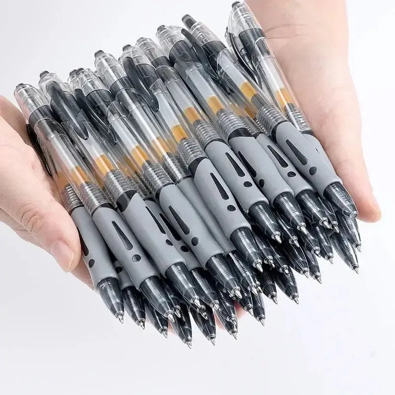 Una mano sostiene un juego de bolígrafos retráctiles de gel negros y plateados.