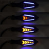 A close-up view of a universal 12V motorcycle LED flowing turn signal indicator with blue and orange light patterns.