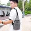 A man wearing a white t-shirt and carrying a gray fanny pack with an adjustable strap outdoors.