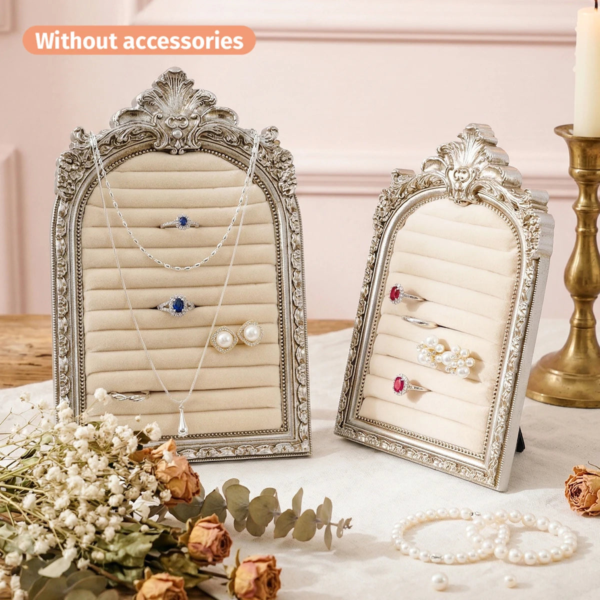 Silver arched resin jewelry display stand featuring a hand-painted floral design holding various rings and necklaces.