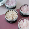 A close-up of a silicone daisy mold used for making candles, featuring pink and cream colored wax.