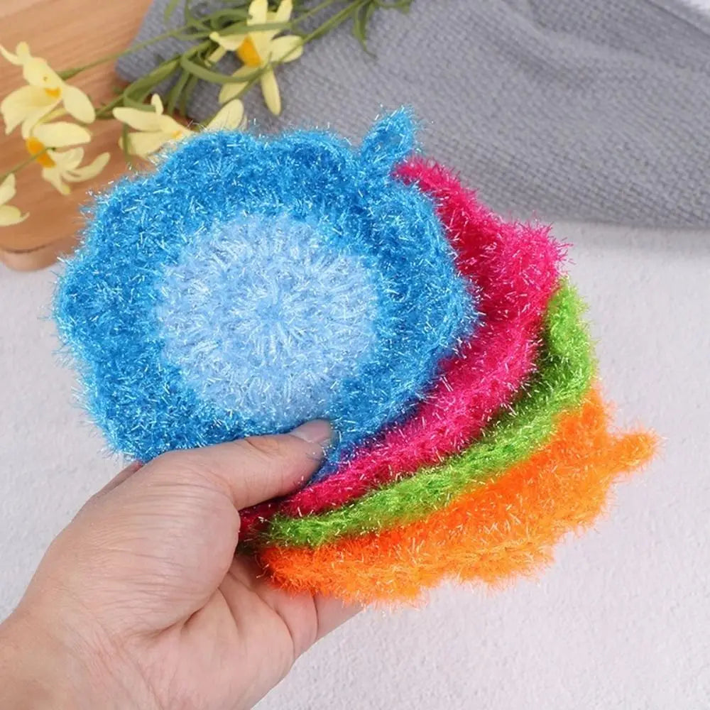 A hand holds a stack of colorful acrylic non-stick dish sponges in shades of blue, pink, green, and orange.