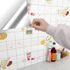 A hand is applying self-adhesive marble contact paper featuring colorful food illustrations onto a white surface.