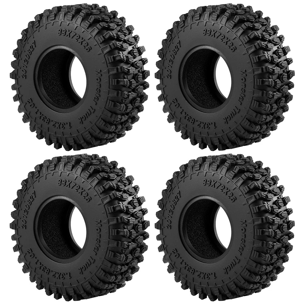 A set of four black mud terrain rubber tires for RC crawlers, showing the tread pattern and mounting holes.
