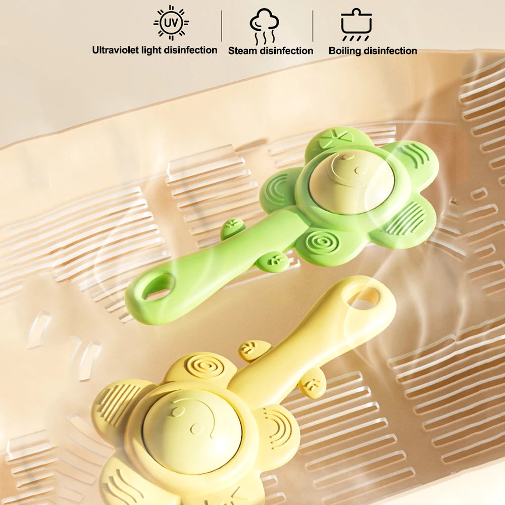 A yellow baby teething rattle with a green chewable gripper and shaker toy shown on a translucent surface.