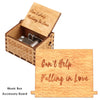 A wooden music box with an accessory board showing the text Can't Help Falling in Love