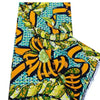 A close-up view of pink glitter African wax print fabric with yellow and green patterns.
