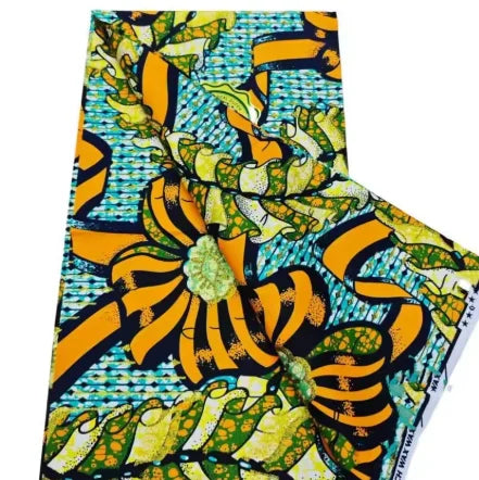 A close-up view of pink glitter African wax print fabric with yellow and green patterns.