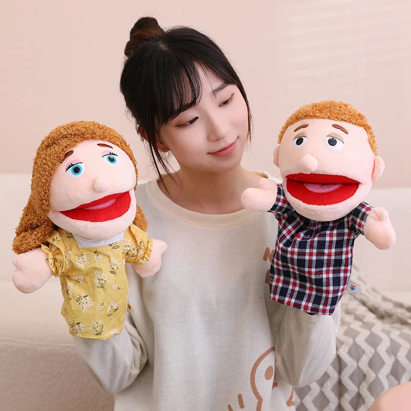 A woman is holding two soft plush hand puppets for kids, one with curly hair and another with red hair.