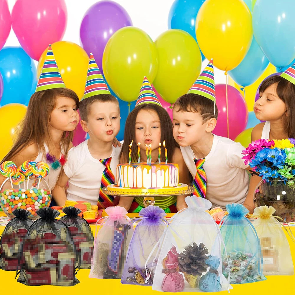 A collection of white organza drawstring bags for gifts and party favors displayed on a yellow surface.